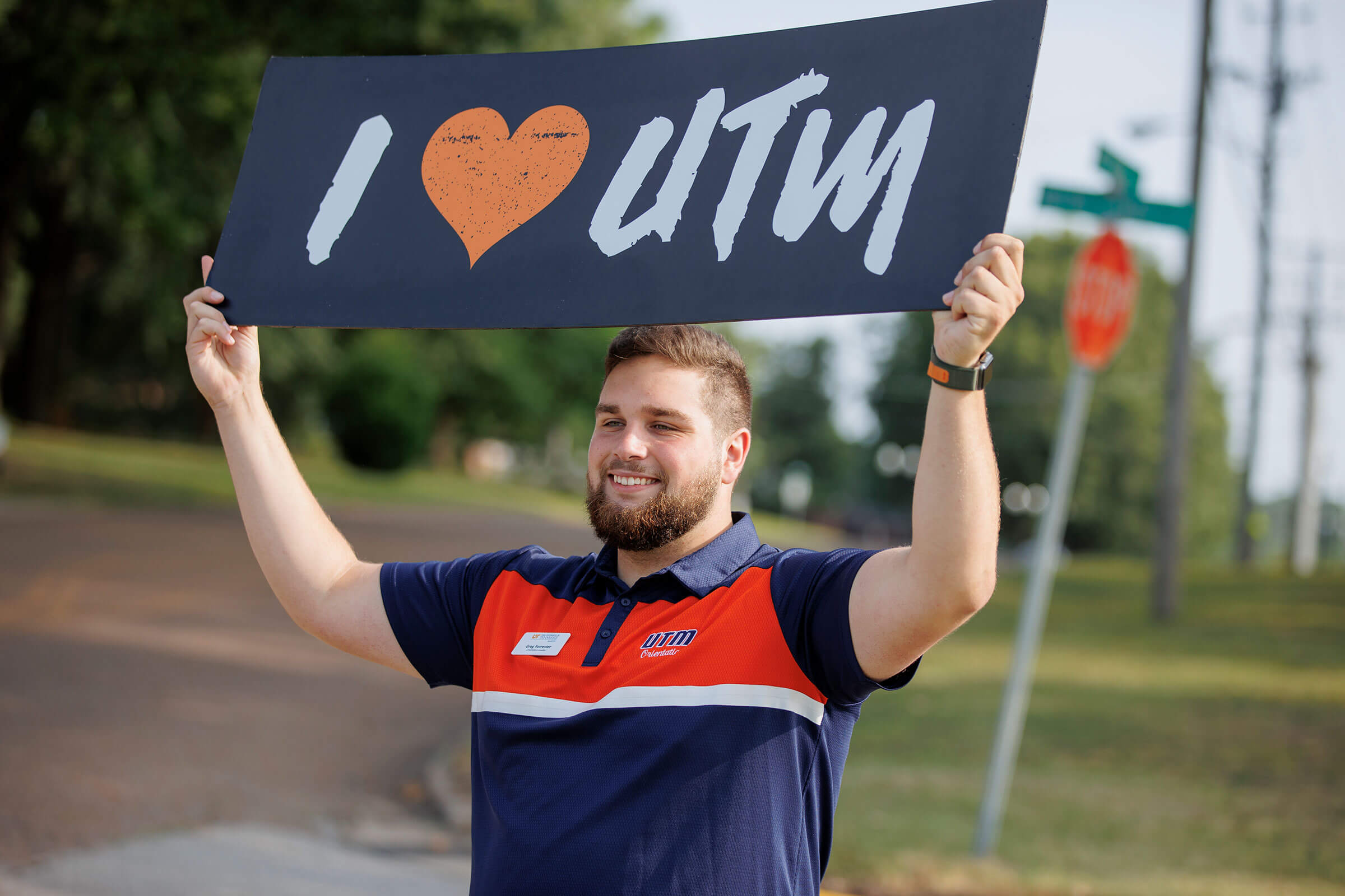 Staff member holds up an I heart UTM sign.