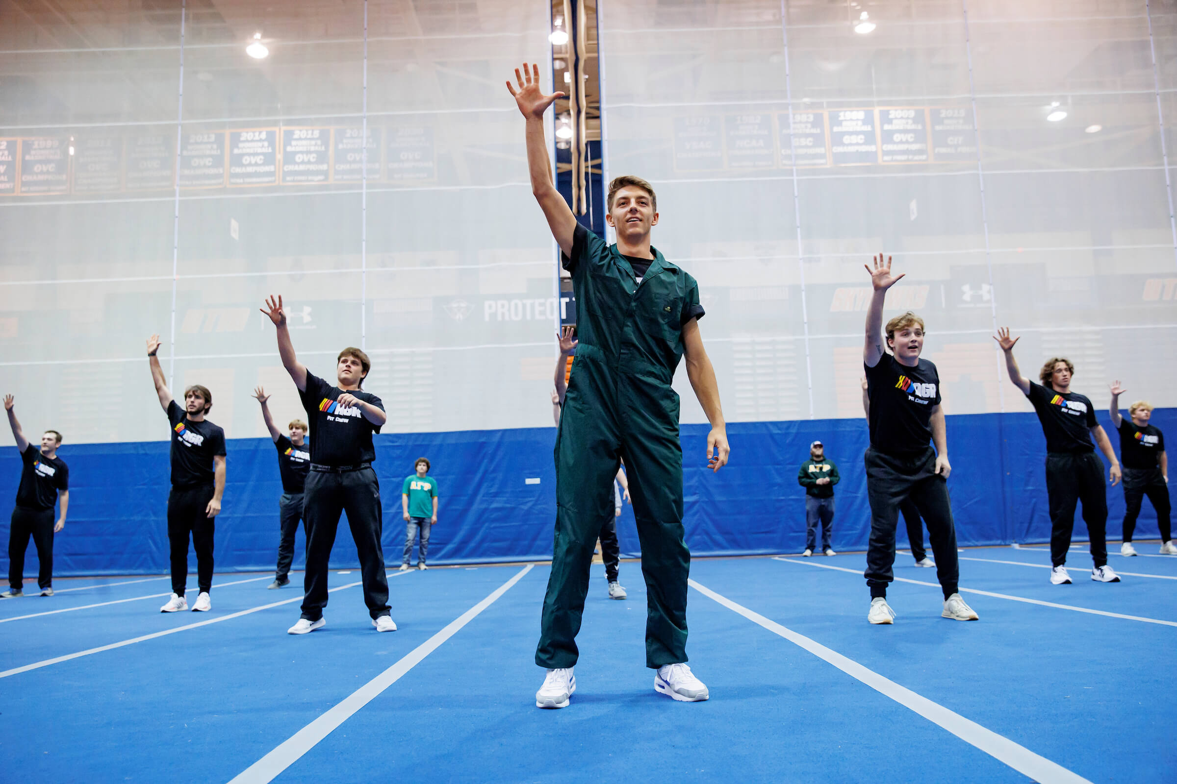 Students waving to an audience during a performance.