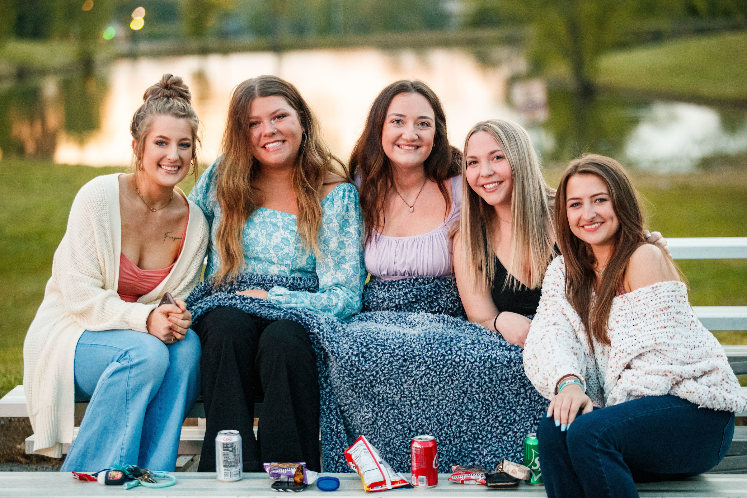 Students smiling next to Pacer Pond